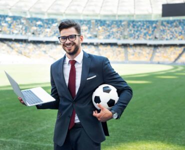 Smiling,Young,Businessman,In,Suit,With,Laptop,And,Soccer,Ball